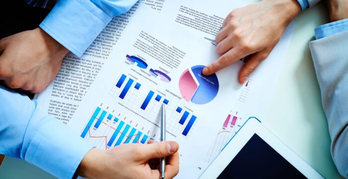 Close-up of female and male hands pointing at business document while discussing it